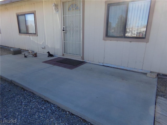 view of exterior entry with a patio