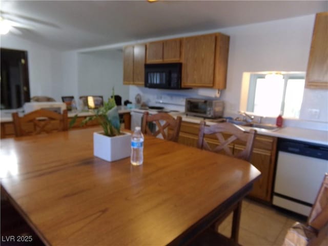 kitchen with white appliances, a toaster, a sink, light countertops, and brown cabinets