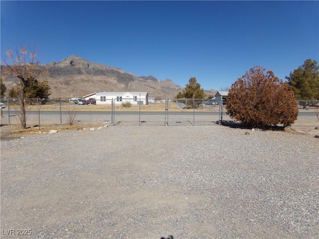 view of yard featuring a gate, a mountain view, and fence