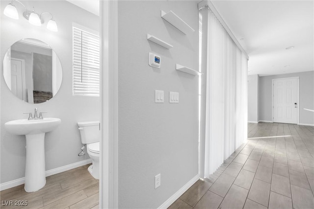 corridor featuring sink and light hardwood / wood-style flooring