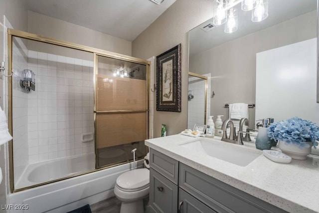 full bathroom with vanity, combined bath / shower with glass door, and toilet