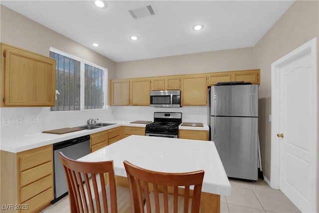 kitchen featuring a kitchen island, appliances with stainless steel finishes, sink, and light brown cabinetry