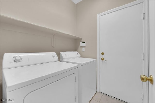 laundry room with washing machine and dryer and light tile patterned floors