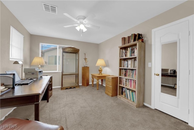 carpeted office space featuring ceiling fan