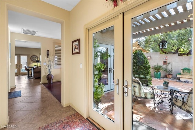 doorway with dark tile patterned flooring and french doors