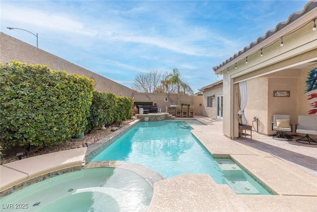 view of swimming pool featuring a patio area and an in ground hot tub