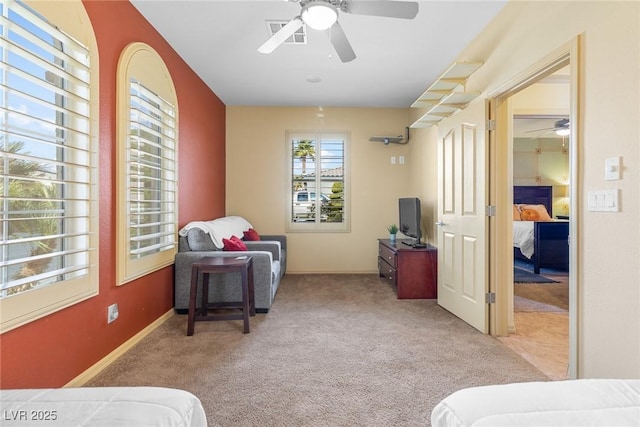 living area featuring ceiling fan and light colored carpet