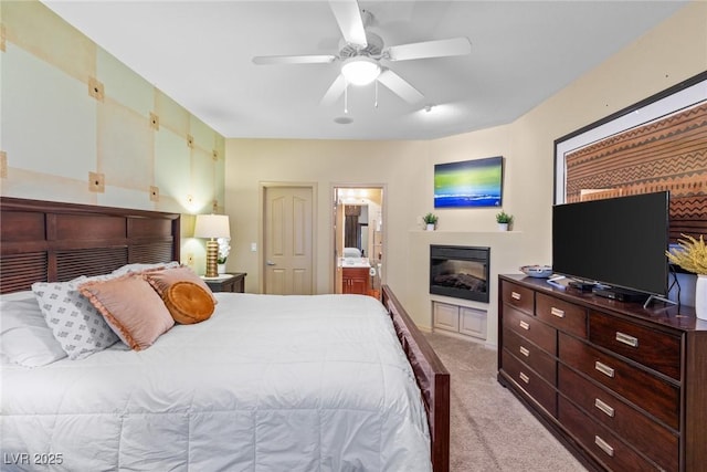 carpeted bedroom featuring connected bathroom and ceiling fan