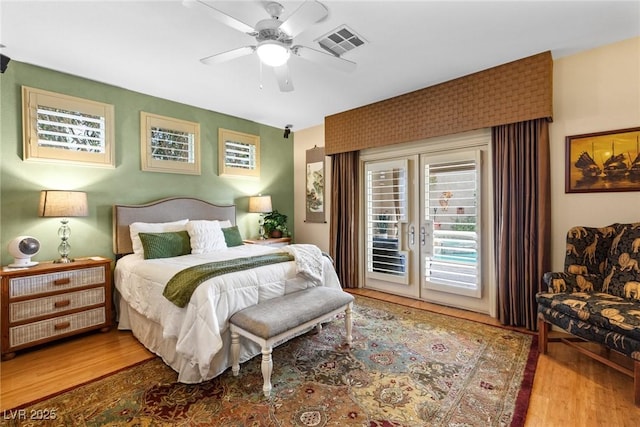 bedroom with hardwood / wood-style floors, access to outside, and ceiling fan