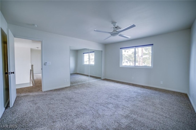 unfurnished bedroom featuring ceiling fan, a closet, and light carpet