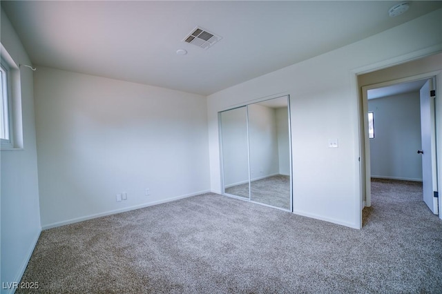 unfurnished bedroom featuring carpet floors and a closet