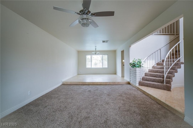 unfurnished living room featuring ceiling fan with notable chandelier and carpet floors