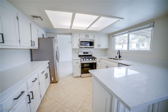 kitchen with stainless steel appliances, kitchen peninsula, sink, and white cabinets