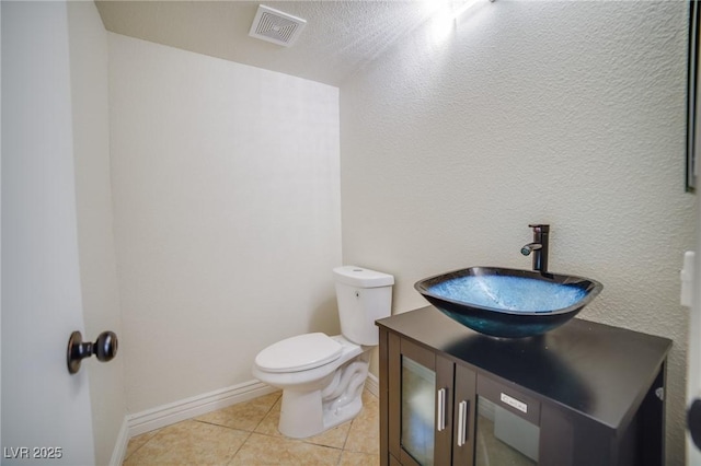 bathroom featuring vanity, tile patterned flooring, and toilet