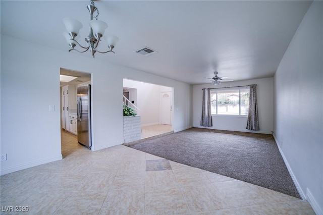 spare room featuring ceiling fan with notable chandelier and light colored carpet