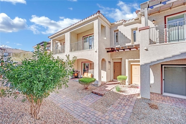 view of front of property featuring a patio and a balcony