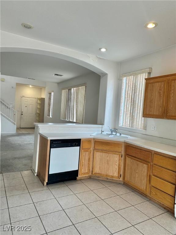 kitchen with sink, light tile patterned floors, and dishwashing machine