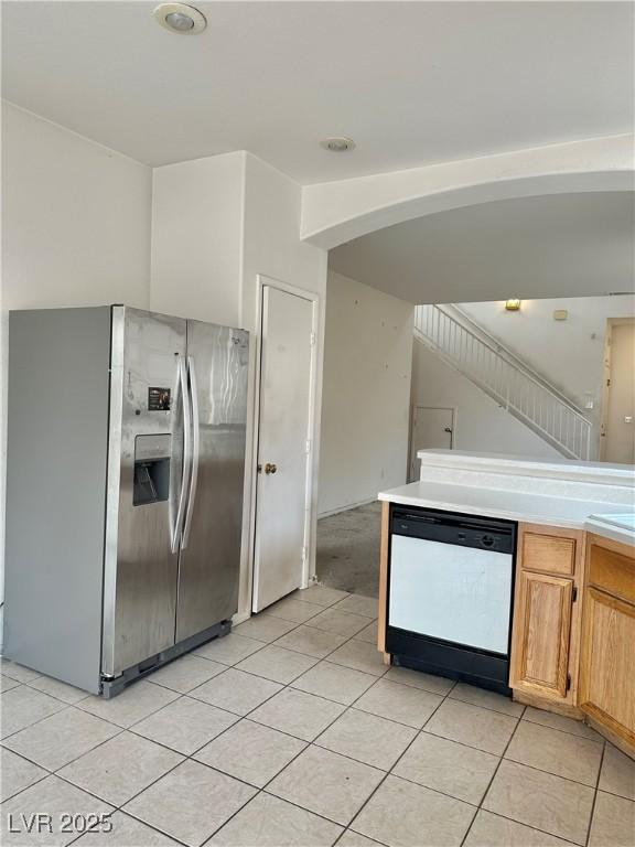 kitchen featuring stainless steel refrigerator with ice dispenser, dishwashing machine, and light tile patterned floors