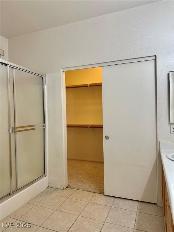 bathroom with tile patterned flooring, vanity, and a shower with shower door