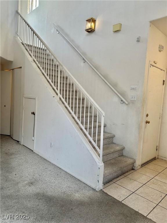 stairway featuring a towering ceiling