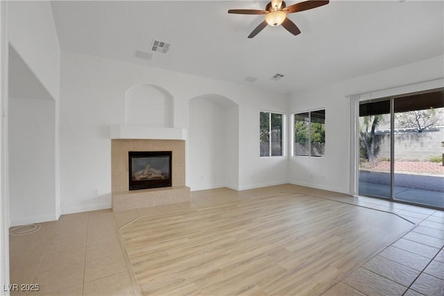 unfurnished living room with a fireplace, light hardwood / wood-style floors, and ceiling fan