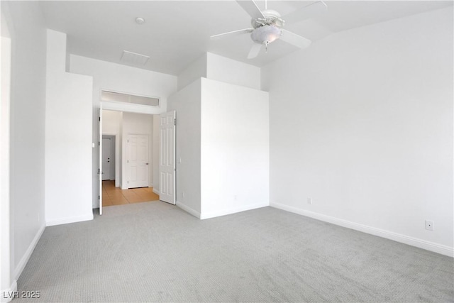 spare room featuring light carpet, vaulted ceiling, and ceiling fan