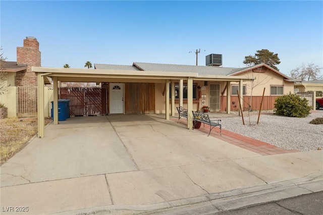 ranch-style home featuring a carport and central AC