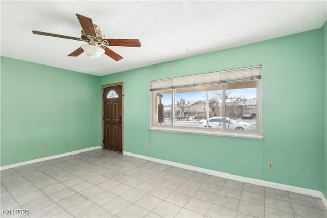 empty room with ceiling fan and a textured ceiling