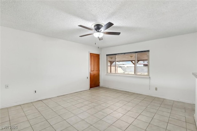 empty room with ceiling fan and a textured ceiling