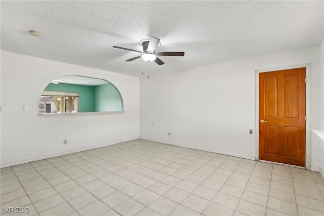 unfurnished room with ceiling fan and a textured ceiling