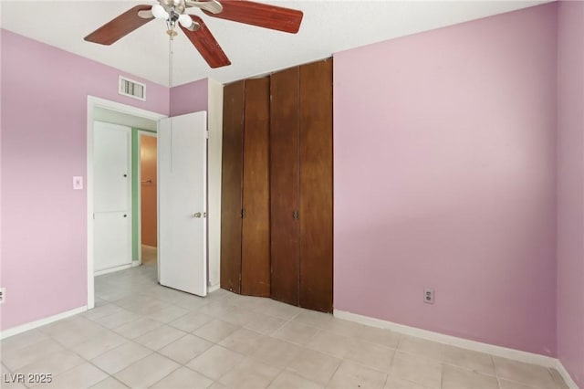 unfurnished bedroom with ceiling fan and a closet