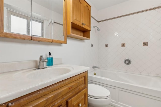 full bathroom featuring vanity, tiled shower / bath combo, and toilet