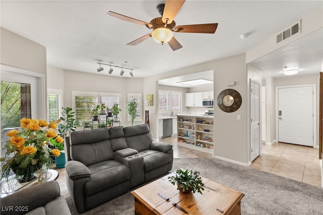 living room featuring light tile patterned flooring, a textured ceiling, and ceiling fan