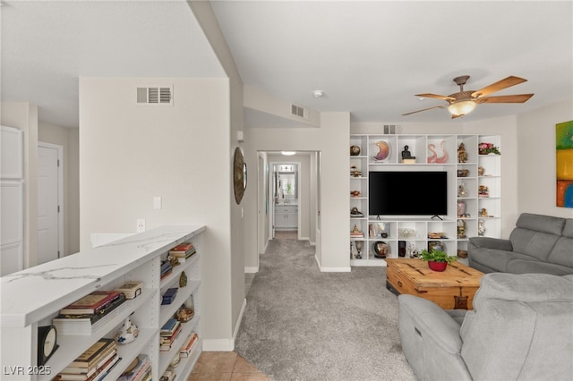 carpeted living room with ceiling fan