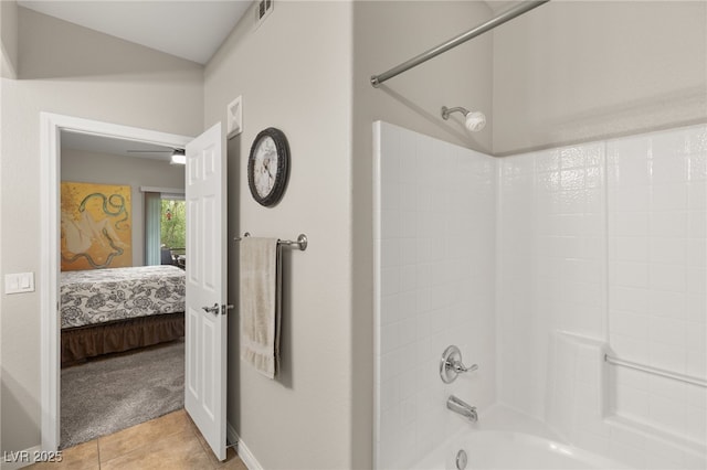 bathroom with tile patterned floors, vaulted ceiling, and  shower combination