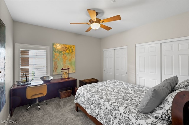 carpeted bedroom featuring multiple closets and ceiling fan