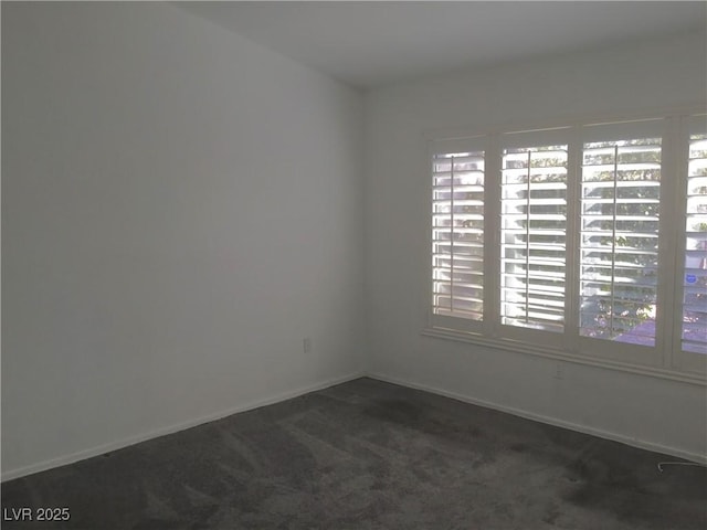 empty room with a healthy amount of sunlight and dark colored carpet