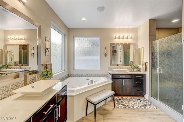 bathroom with shower with separate bathtub, hardwood / wood-style floors, and vanity