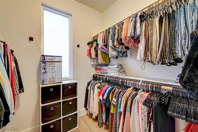 walk in closet with light hardwood / wood-style flooring