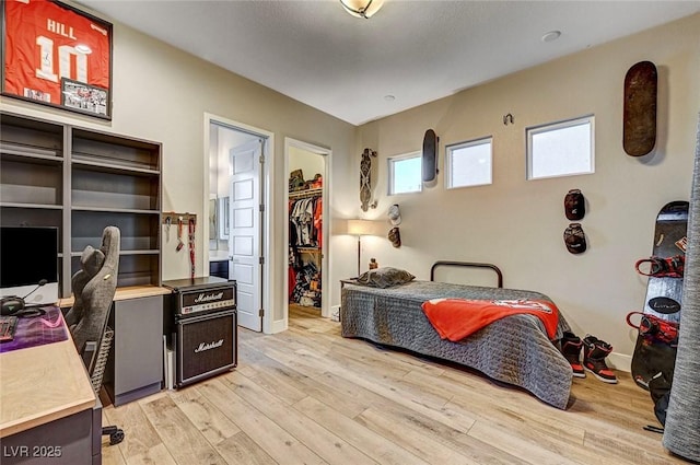 bedroom featuring a walk in closet and light wood-type flooring