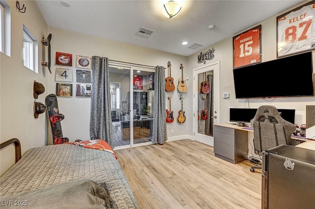 bedroom with access to exterior and light hardwood / wood-style floors