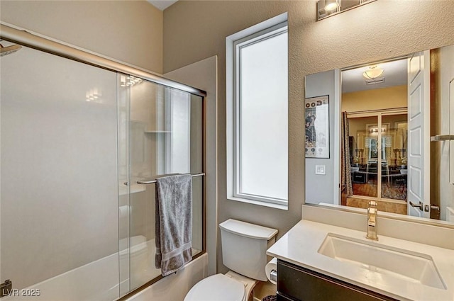 full bathroom featuring bath / shower combo with glass door, vanity, and toilet