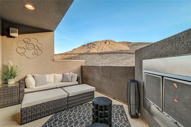 balcony with an outdoor living space and a mountain view