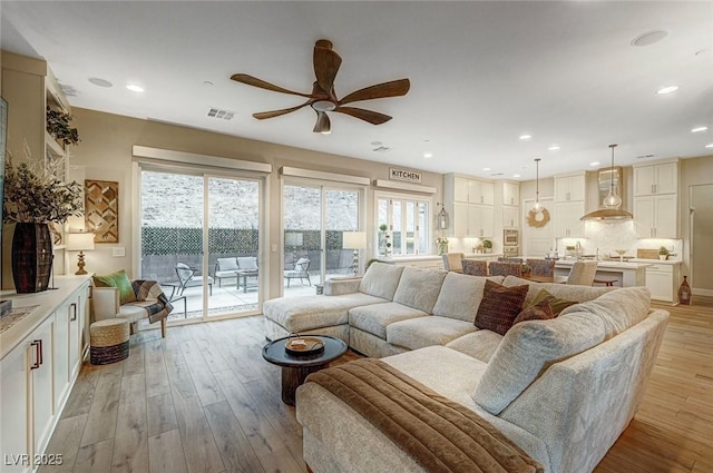 living room with ceiling fan and light hardwood / wood-style floors