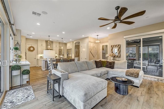 living room with ceiling fan and light wood-type flooring