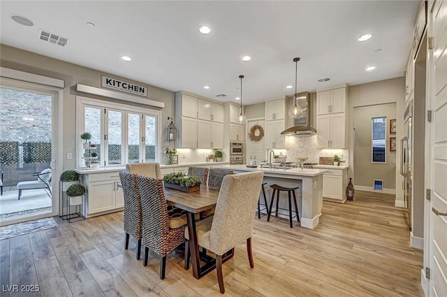 dining area with sink and light hardwood / wood-style floors