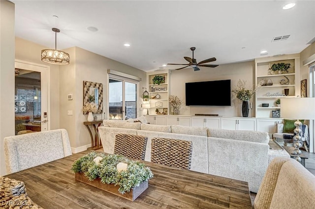 dining space featuring hardwood / wood-style floors, built in features, and ceiling fan