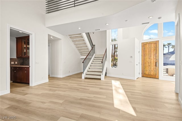 foyer entrance featuring a wealth of natural light, light hardwood / wood-style floors, and a high ceiling