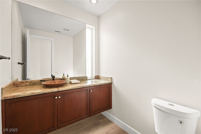 bathroom with vanity, wood-type flooring, and toilet