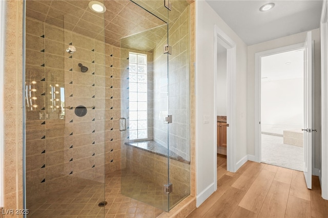 bathroom with hardwood / wood-style flooring and a shower with shower door